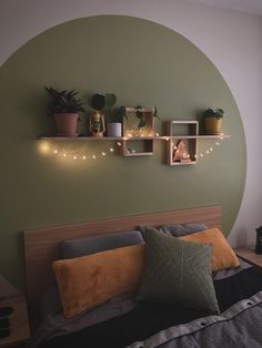 a bed with two shelves above it that have plants on them and lights strung across the wall