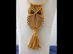 a yellow necklace with an owl design on it's face and beads around the neck