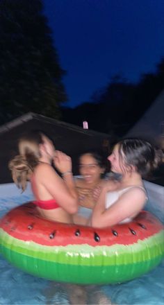 three girls in a watermelon float on the pool with their arms around each other