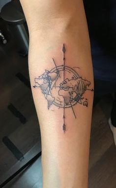 a tattoo on the arm of a woman with a compass and world map in it