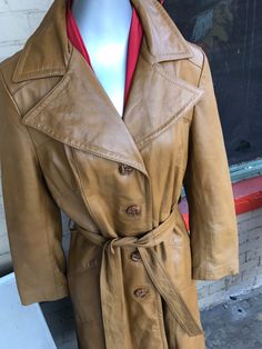 "This is so soft and gorgeous! I love the leather and the pointed collar that is so iconic for the 60's! It's a 24k dan di modes brand. With lovely gold like buttons and it's in excellent vintage condition with a lovely satin lining! There is no size shown and measurements are taken flat and buttoned Measures: Shoulder to shoulder: 15.5\" Waist: 16\" Arm length: 22.5\" Shoulder to hem: 45\" belt length: 65\" Bust area: 15\" Thighs: 17\" Thank you so much for looking and have a very blessed day!! Vintage Gold Outerwear For Fall, Gold Outerwear For Business In Fall, Gold Business Outerwear For Fall, Vintage Collared Leather Jacket With Button Closure, Vintage Outerwear With Snap Buttons For Office, Fall Vintage Outerwear With Gold Buttons, Brown Leather Coat, Leather Coat Womens, Area 15