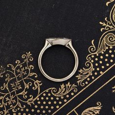 a silver ring sitting on top of a black cloth