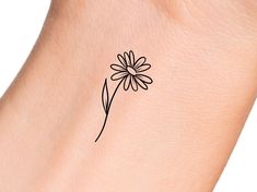 a small flower tattoo on the wrist