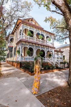 a woman standing in front of a large house