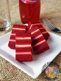 red jello is on a white plate next to a fork