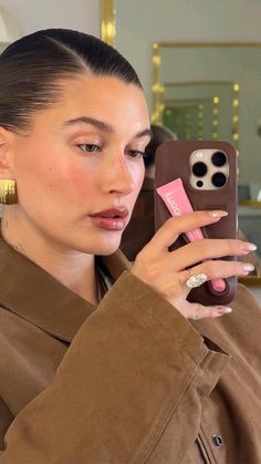 a woman taking a selfie with her cell phone in front of her earring