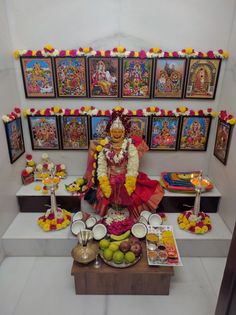 there is a small shrine with food on the table and pictures behind it that have been decorated