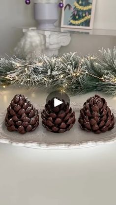 three pine cones sitting on top of a plate