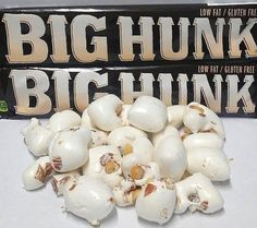 a pile of white mushrooms sitting next to a box of big hunk chocolates