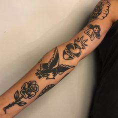 a man's arm with tattoos on it and an eagle, flowers, and hearts