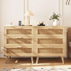 a wooden dresser with wicker drawers next to a chair and lamp on the floor