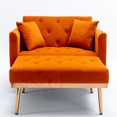 an orange couch with two pillows on it