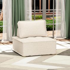 a white chair sitting on top of a rug in front of a sliding glass door