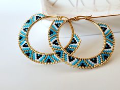 two pairs of hoop earrings with blue and black beaded details on the inside of them