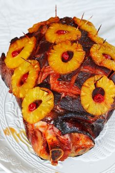 a piece of pineapple upside down cake on a white plate with fruit toppings