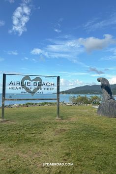 a sign for the airlie beach health and dental care area in front of an ocean