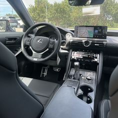 the interior of a car with steering wheel, dashboard and dash board showing various electronic devices