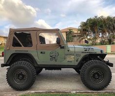 the jeep is parked on the side of the road in front of some palm trees