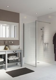 a bathroom with a sink, mirror and shower stall in the middle of the room