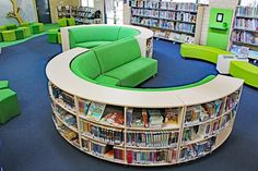 a library with green and white furniture and bookshelves