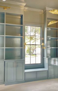 an empty room with built in bookshelves and windows