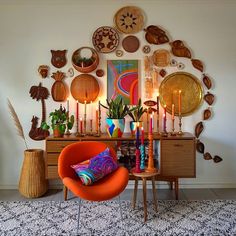 an orange chair sitting in front of a wooden table with candles on top of it