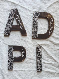 three metal letters that spell out the word dad, daddy, and daughter on white paper