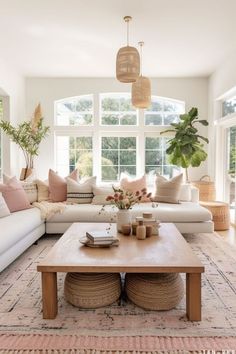 a living room with white couches and pink pillows on top of the rugs