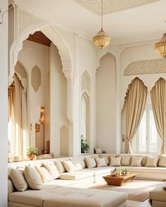 an ornate living room with white walls and beige couches in front of large windows