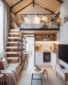 a loft apartment with stairs leading up to the bedroom and living room, as well as kitchen