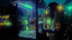 a man standing in front of a fish tank filled with lots of water and gravel