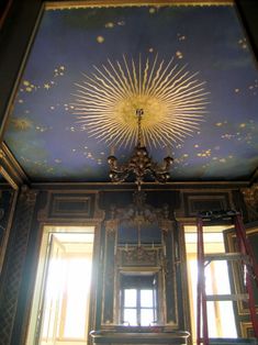 the sun is shining brightly on the ceiling in an ornate room with blue walls and gold trimmings