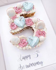 the number five cake is decorated with pink and blue icing