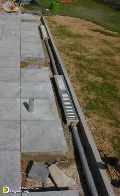 a cement bench sitting in the middle of a yard next to a fence and grass