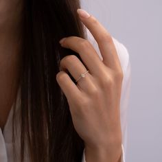 a woman's hand with a diamond ring on her finger