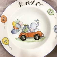 a plate with an elephant driving a car and balloons