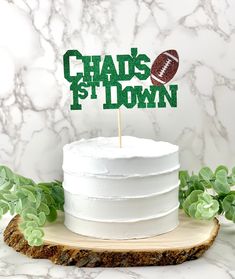 a cake with a football on top and the words chad's 1st down written in green