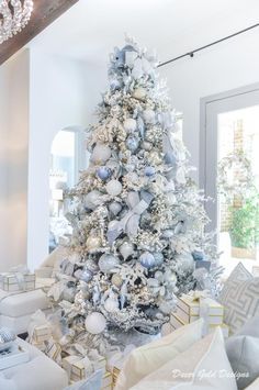 a white christmas tree with blue and silver ornaments