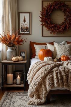 a bedroom decorated for fall with pumpkins and candles