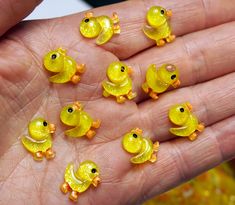 small yellow rubber ducks in the palm of someone's hand