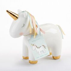 a white ceramic unicorn figurine with gold trimmings and a tag on it