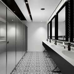 a bathroom with black and white tile flooring next to two large mirrors on the wall