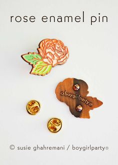 the brooches are made from wood and have different designs on them, including roses