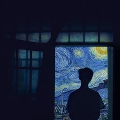 a man standing in front of a window with the starry night painting on it