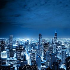 an aerial view of a city at night with the lights on and skyscrapers lit up