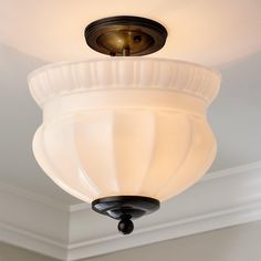 a light fixture hanging from the ceiling in a room with white walls and trimmings