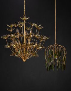 two gold chandeliers with green leaves hanging from them