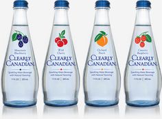 four bottles of clear water with fruit on the top and one bottle containing cranberry canadian