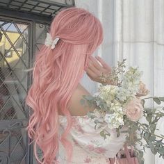 a woman with long pink hair holding flowers