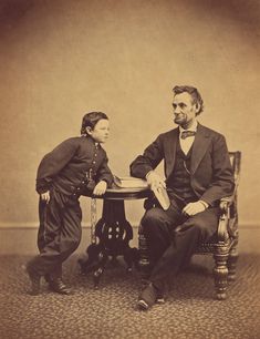 an old photo of two men sitting at a table